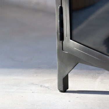 Detalle del acabado de armario bajo de metal negro con puertas de cristal de Tine K Home