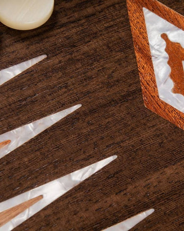 Detalle de incrustaciones claras iridiscentes y rombo de madera.