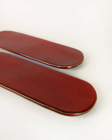 Set de dos bandejas de cerámica roja dispuesto sobre la mesa