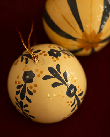 Detalle de una bola de fondo crema con dibujos vegetales azules.