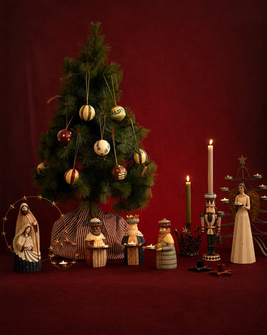 Ambiente navideño con árbol decorado, candelabros y adornos de colores.