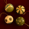 Bolas de Navidad de papel maché en tonos verdes de Mahe Homeware, con dibujos en verde y crema.