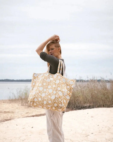 Bolsa shopper Bonheur du Jour Tupia Absinthe llevada al hombro en la playa