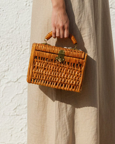 Bolso mini de mimbre llevado en la mano