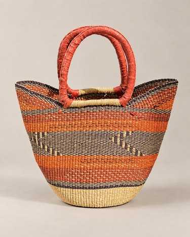 Bolso shopper artesanal de fibras naturales naranja, con dibujo geométrico y asas rojas, de Matuta Home