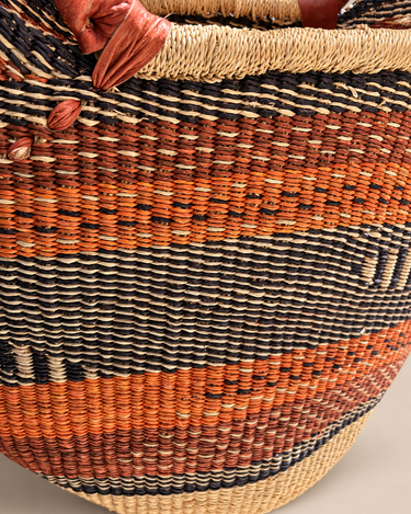Detalle de cestería artesanal para bolsos shopper: fibras naturales trenzadas en naranja, natural y tonos oscuros