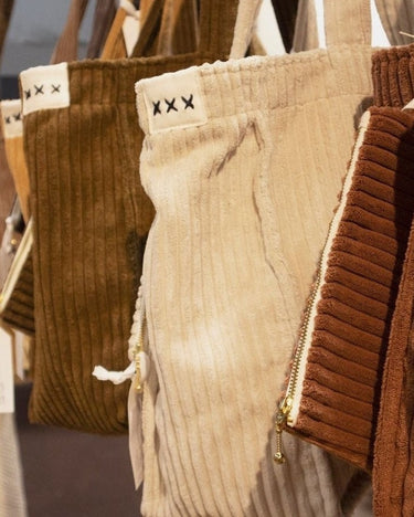 Bolsos de pana de Bed and Philosophy en tonos marrones y claros, colgados juntos