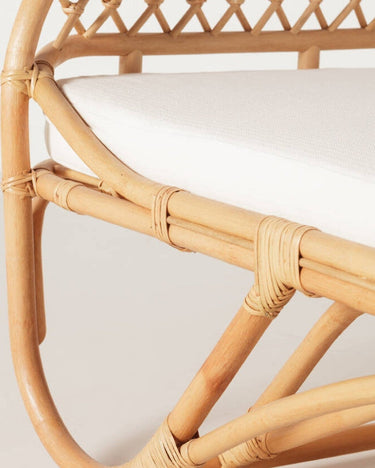 Cama exterior de ratán con colchoneta blanca