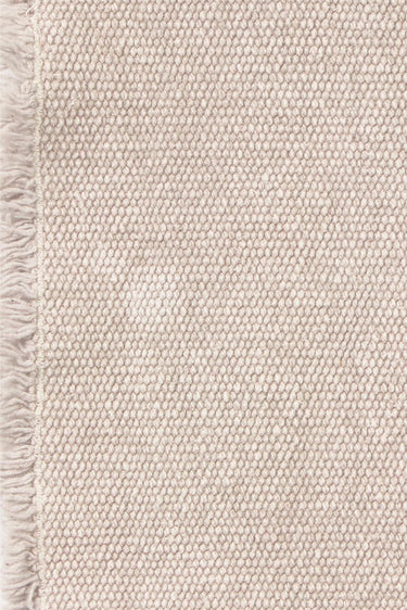 Detalle de los bordes deshilachados de un camino de mesa gris