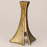 Candelabro brutalista de bronce vintage sobre fondo topo claro