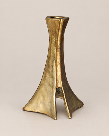 Candelabro brutalista de bronce vintage sobre fondo topo claro