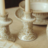 Candelabro de gres con hojas pintadas en beige de Leandro Cano, junto a otro modelo con velas blancas