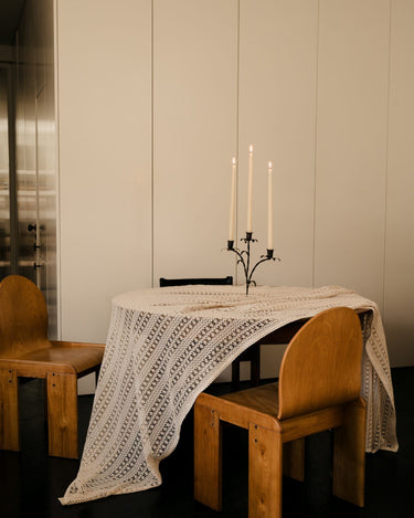 Candelabro de tres brazos encendido en una mesa de comedor