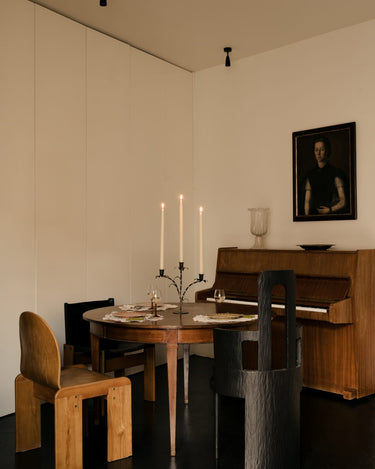 Candelabro floral de tres brazos en una mesa dentro de un salón