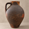 Cántaro de barro oscuro con cuello ocre vintage sobre fondo topo claro