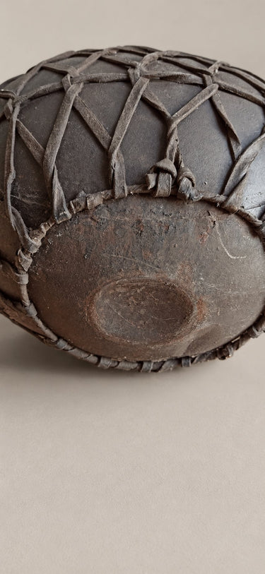 Cántaro decorativo oscuro con entramado de tiras — base y extremos de las tiras