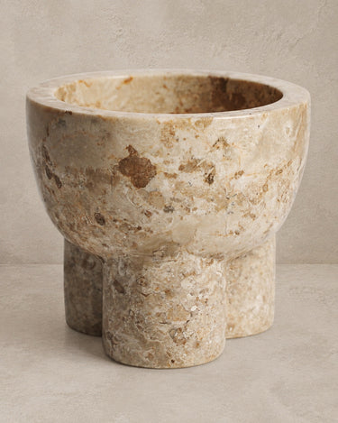 Centro de mesa de mármol beige de Vical sobre fondo topo claro