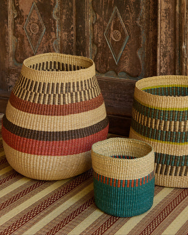 Cestas de fibras naturales de varios colores junto a un panel de madera