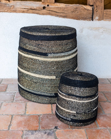 Cestas con tapa de dos tamaños junto a una pared mineral de Caravane