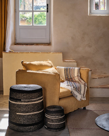 Cestas junto a un sillón y una ventana de Caravane