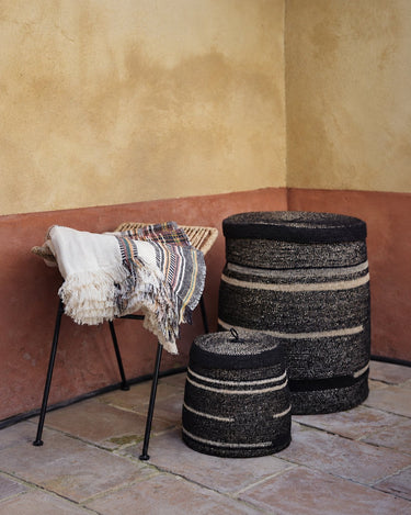 Cestas junto a una silla con textiles de Caravane