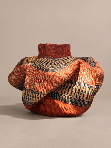 Cestería de Ghana: vista lateral de la cesta ondulada con motivos negros y naturales
