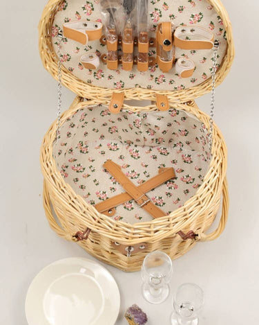Cesta de picnic corazón de mimbre natural para dos de PIETRA DI CASA, abierta junto a platos y vasos