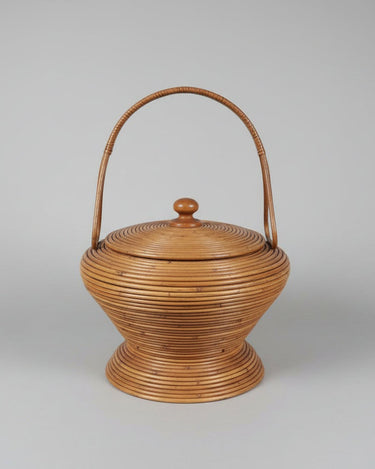 Cesta vintage con tapa y asa arqueada, cuerpo redondeado y bandas horizontales en tono miel