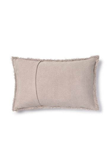 Cojín rectangular de algodón gris sobre un sofá natural