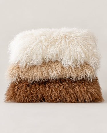 Cojines de piel de cordero tibetano de Van Buren apilados en tonos blanco, beige y marrón
