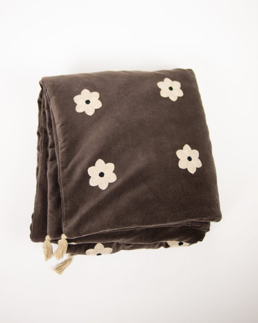 Colchoneta Daisy café plegada con flores claras y borlas de Olsson & Jensen