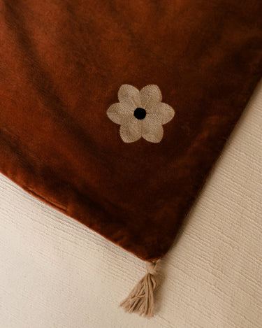 Detalle de la esquina y la borla de la colchoneta Daisy óxido