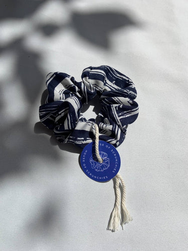 Coletero de House of Scrunchies: coletero junto a sombras de plantas, modelo azul marino y blanco