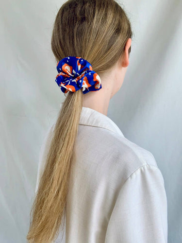 Coletero de House of Scrunchies: coletero en una coleta vista de lado, modelo azul y naranja