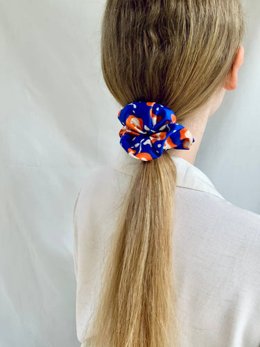 Coletero de House of Scrunchies: coletero en una coleta vista desde atrás, modelo azul y naranja