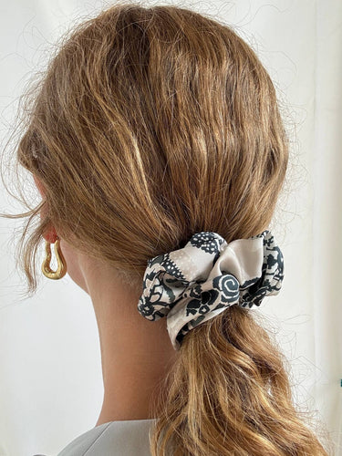 Coletero de House of Scrunchies: coletero en una coleta vista de lado, modelo ornamental verde oliva y blanco