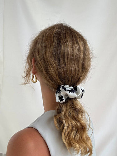 Coletero de House of Scrunchies: coletero en una coleta vista desde atrás, modelo de satén reciclado con flores negras