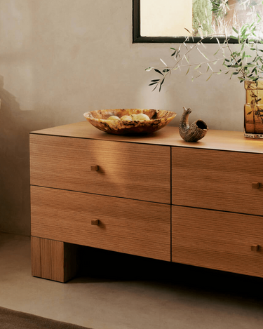 Cómoda baja de chapa de roble con cuatro cajones de Ferm Living: cajonera baja ancha bajo una ventana, con cuatro cajones distribuidos en dos filas y dos columnas.