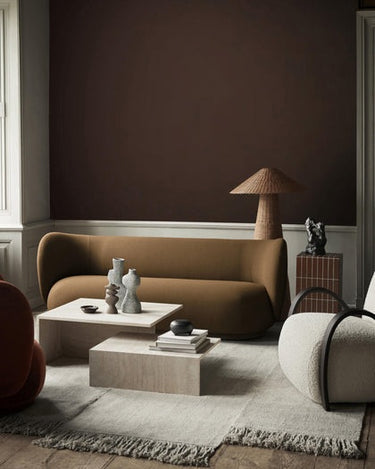 Conjunto de Ferm Living: mesas de centro frente a sofá ocre con cerámicas.