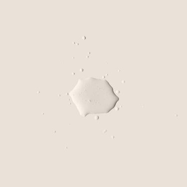 Muestra de líquido claro con gotas dispersas y pequeñas burbujas sobre fondo beige.