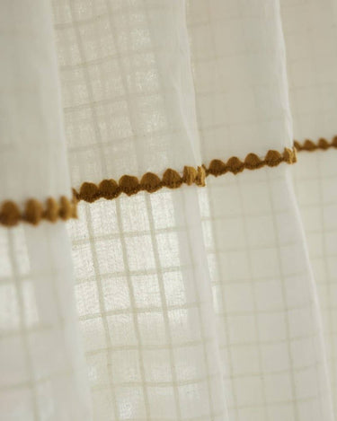 Detalle del ribete ocre sobre el tejido crudo translúcido de la cortina