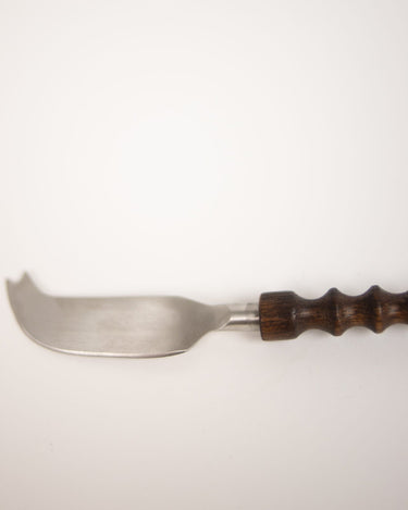 Detalle del cuchillo curvo para queso con punta bifurcada y mango de madera