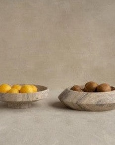 Cuenco decorativo de Kiwano Concept, con fruta, sobre una mesa de piedra