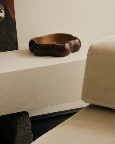 Cuencos decorativos de contorno irregular, con la versión marrón y melocotón sobre una repisa