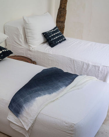 Cojin tie-dye negro blanco en cama natural