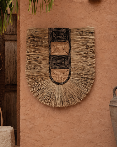 Decoración de pared de pandan natural, colgada en una pared de tono cálido