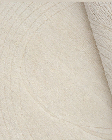 Detalle de alfombra de lana blanca con forma irregular de fósil fluido Fluid Fossil Linie Design