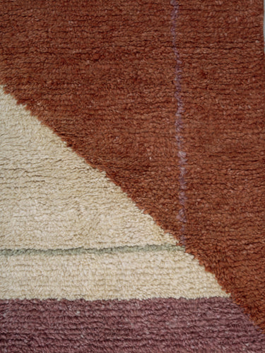 Detalle del dibujo rojizo y crema de la alfombra de lana Optical Echo