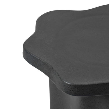 Detalle del tablero irregular de la mesa auxiliar de gres negro mate