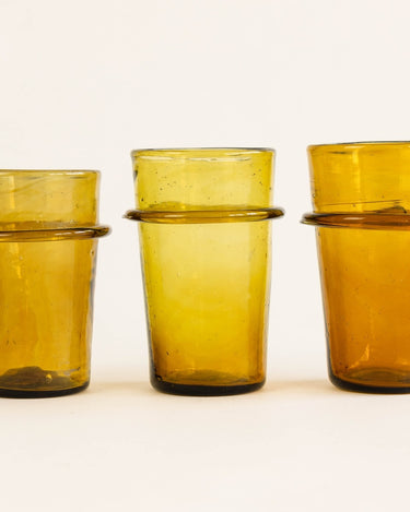 Detalle de vaso marrón de vidrio soplado artesanal